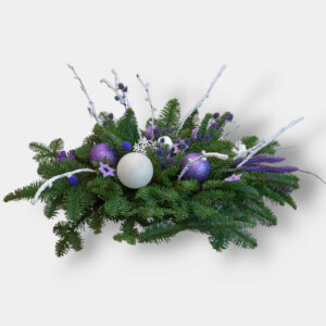 Elegancki stroik w fioletowej tonacji na naturalnej jodle skomponowany z białych i fioletowych bombek oraz białych dodatów